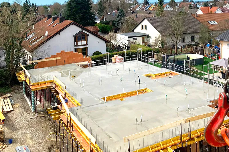 Frisch betonierte Geschossdecke im Rohbau mit Kran